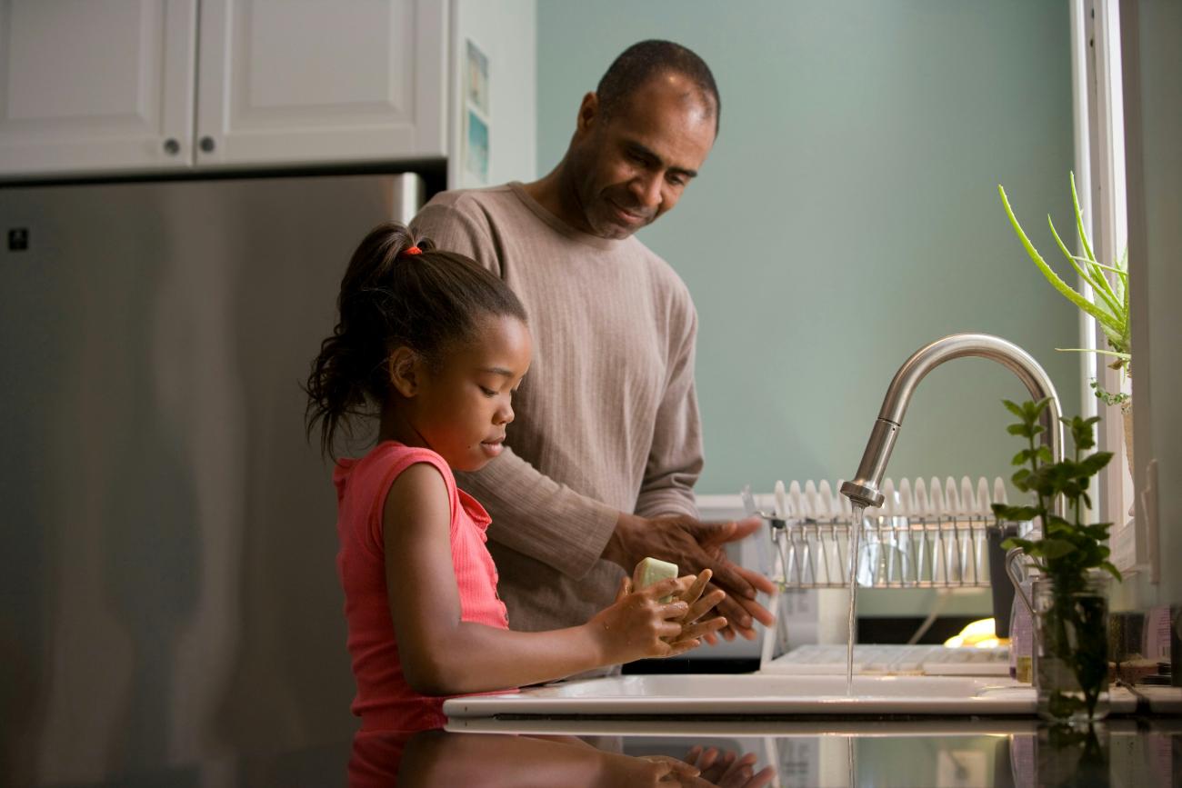father and daughter washing dishes